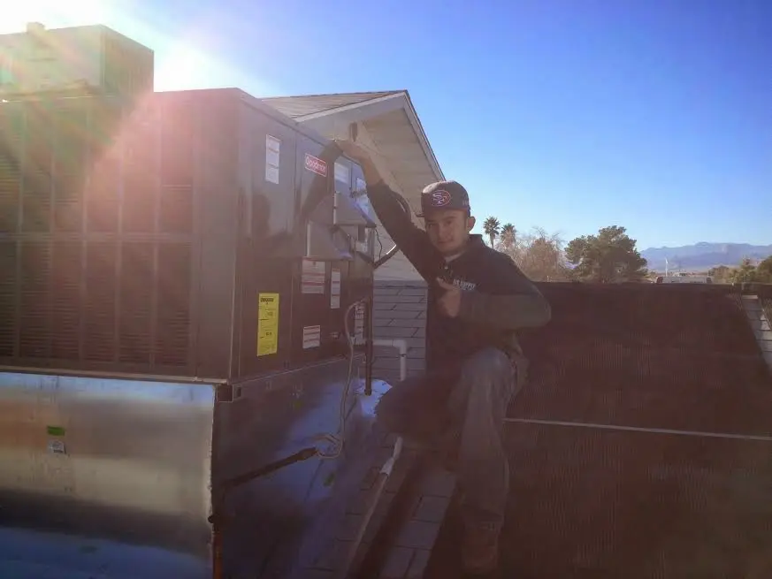 HVAC technician performing Heat Pump Repair on a rooftop unit in Hillcrest